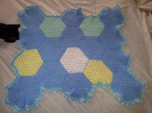 Alex, inspecting the finished baby blanket to be sure it's up to par.